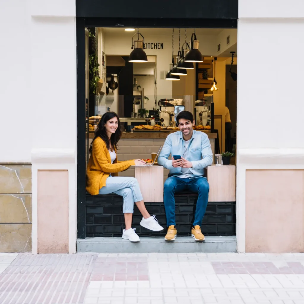 Pareja disfrutando de café en una cafetería local, representando la conexión comunitaria en el SEO local