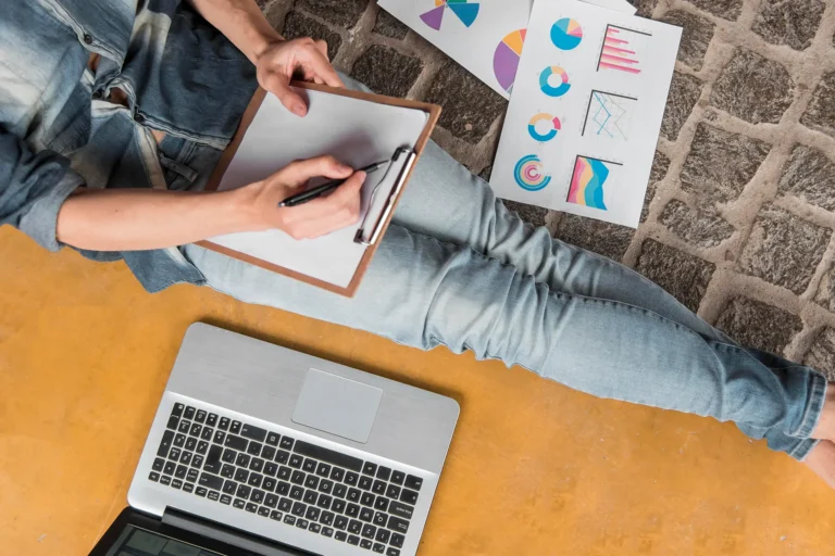 Persona revisando gráficos y notas sobre el posicionamiento web en un portátil