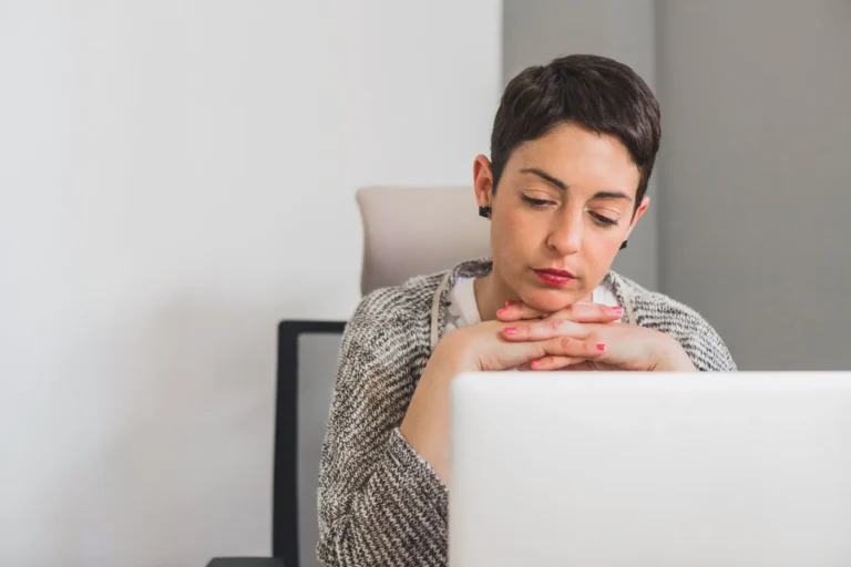 Persona pensando delante del portátil mientras analiza por qué su web no se posiciona