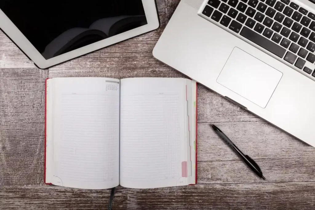 Escritorio de trabajo con portátil, libreta y tablet para mantenimiento web y SEO