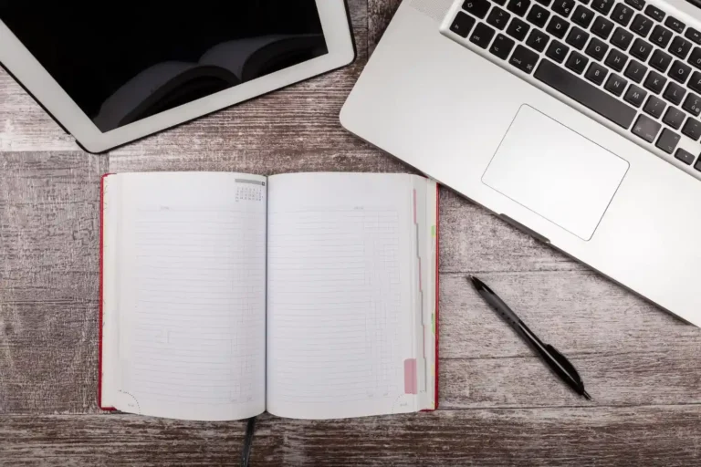 Escritorio de trabajo con portátil, libreta y tablet para mantenimiento web y SEO